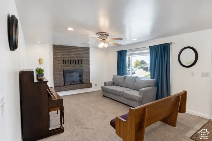 Brick-faced fireplace with a built-in firebox, recessed lighting, and a ceiling fan