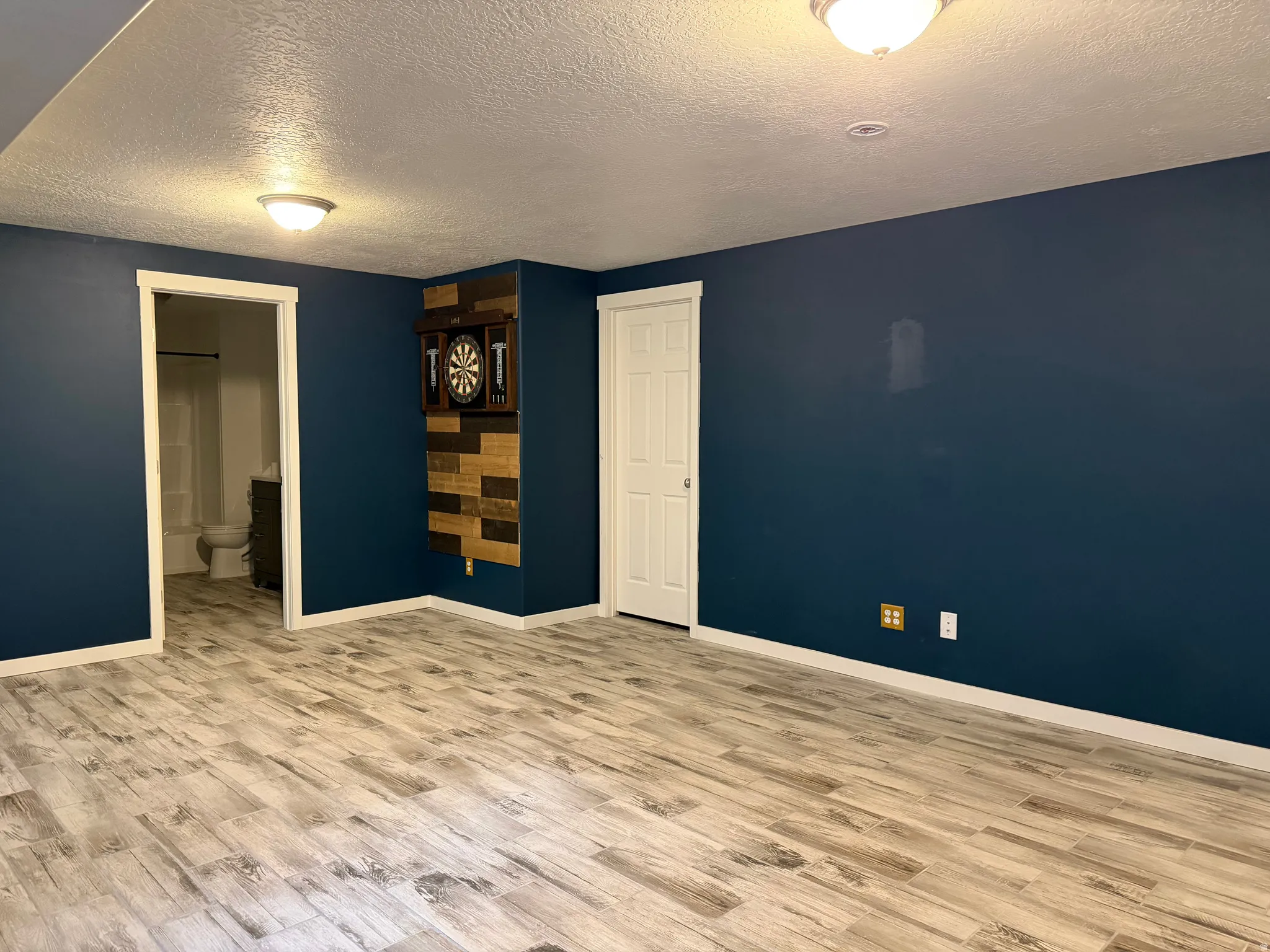 Wood-finish flooring throughout, complemented by a contemporary dark wall color and crisp white trim