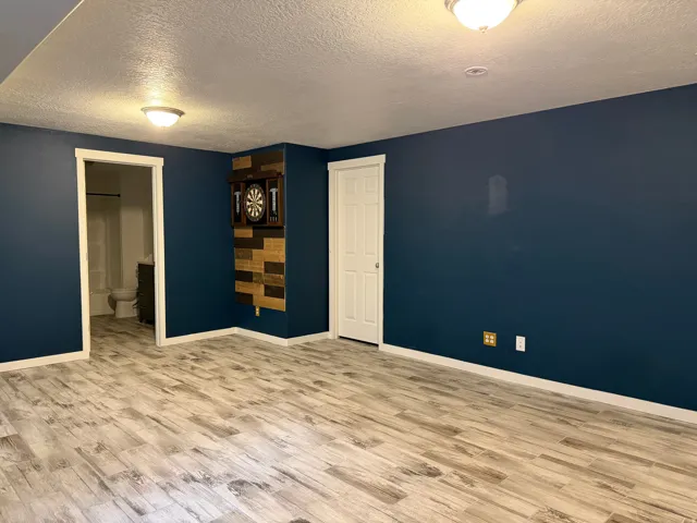 Wood-finish flooring throughout, complemented by a contemporary dark wall color and crisp white trim