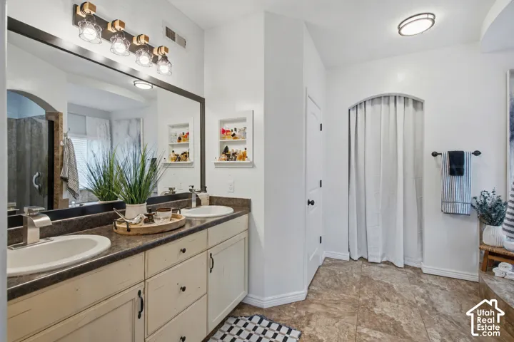 Dual vanity with surface-mounted sinks and dark-toned countertops
