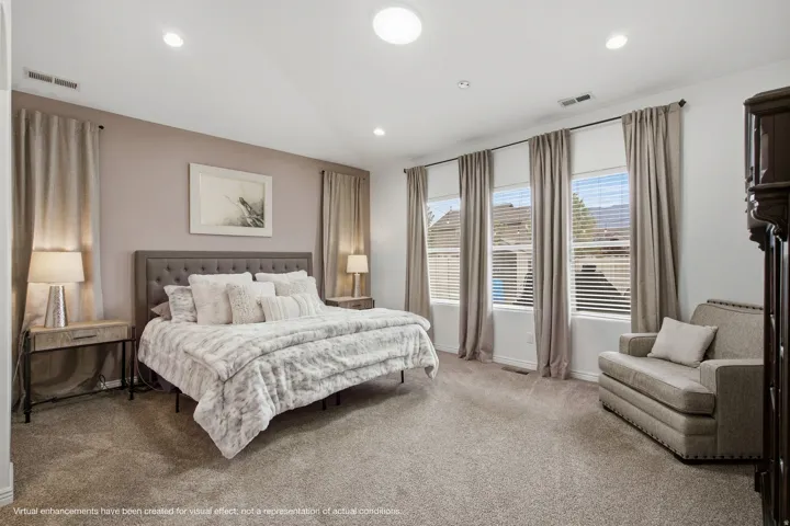 Recessed ceiling lighting, a prominent central skylight, three large windows with blinds, and neutral-toned wall paint