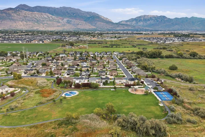 Expansive green space featuring a playground, tennis courts, and walking paths