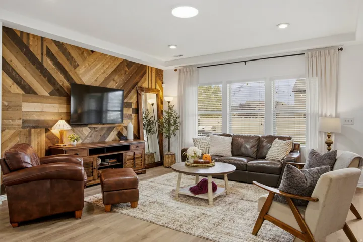 Wood-finish flooring throughout, featuring a recessed ceiling, transom window, and a wood accent wall with a geometric pattern