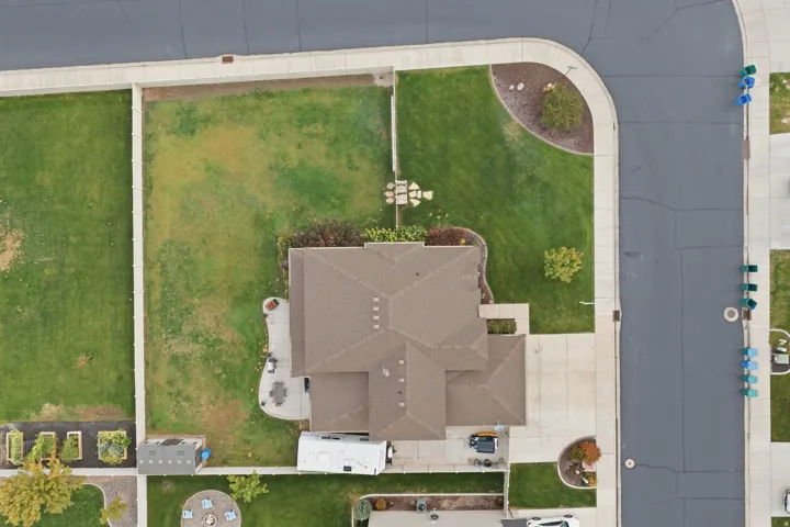 Gable roofline with a concrete driveway, a concrete patio, and a fenced lawn area