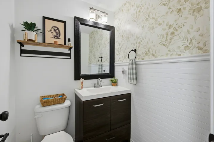 Dark wood-finish vanity with an integrated white sink, framed mirror, and chrome faucet
