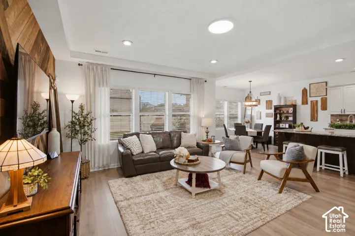 Spacious living area featuring wood-finish flooring, recessed lighting, and large windows