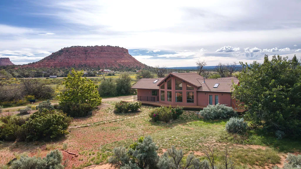 Brick residential home situated on expansive grounds with mature landscaping and native desert vegetation