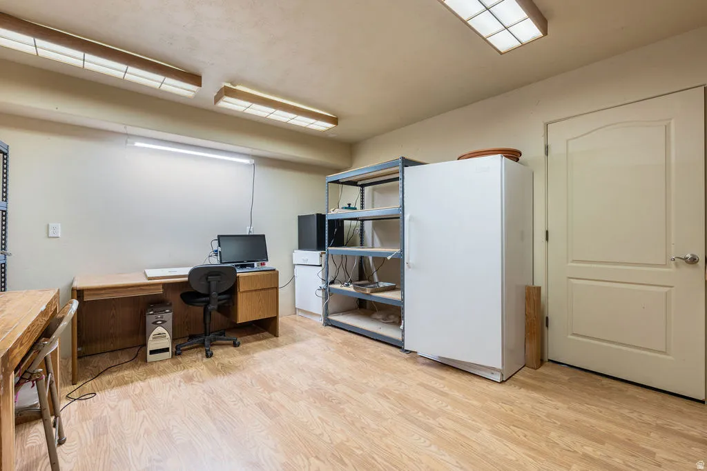Versatile multi-use space featuring wood-finish flooring, recessed ceiling lighting, and built-in shelving with mixed storage solutions