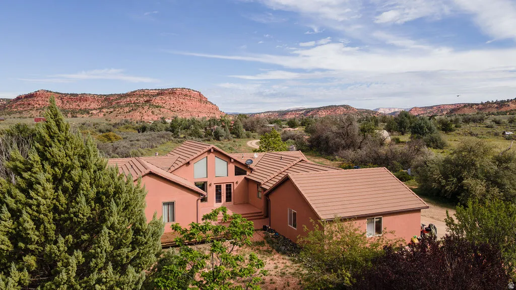 Exterior featuring multiple gables, large window installations, and a desert landscape with prominent red rock formations