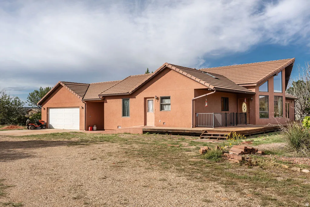 Terracotta stucco exterior with a modern pitched roof and metal accents, complemented by a covered wraparound porch