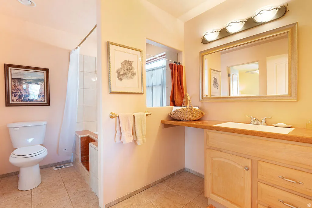 Vanity with wood-finish countertop, integrated sink, and wood cabinetry