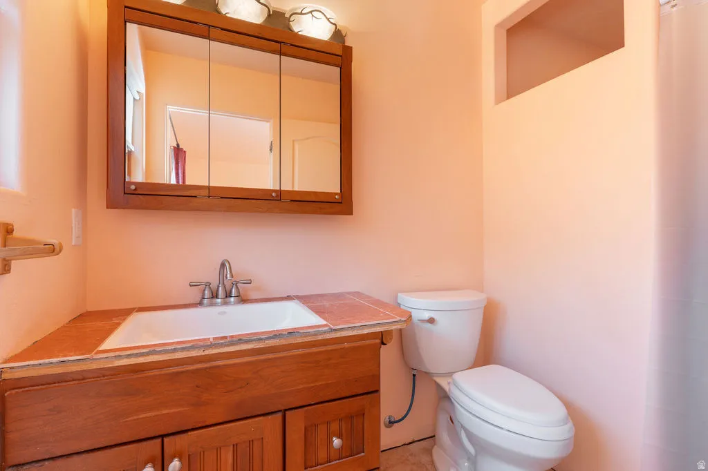 Wood-finish vanity with an integrated sink and tiled countertop