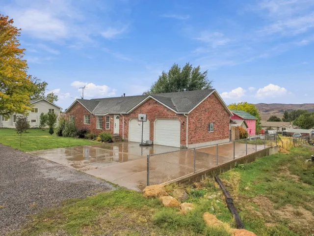 Charming brick residence with an attached two-car garage and expansive concrete driveway