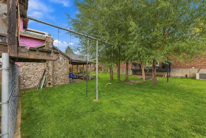 Expansive grounds featuring a manicured lawn, mature shade trees, and established landscaping