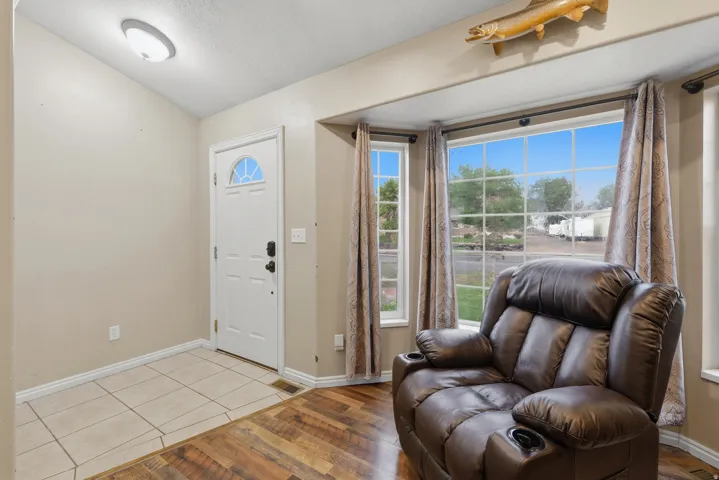 Welcoming entryway featuring tile flooring, a white entry door with transom window, and expansive glass sliding doors that flood the space with natural light