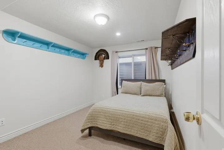 Bright secondary bedroom featuring carpeted flooring, recessed ceiling lighting, large window with natural light, and neutral wall finishes