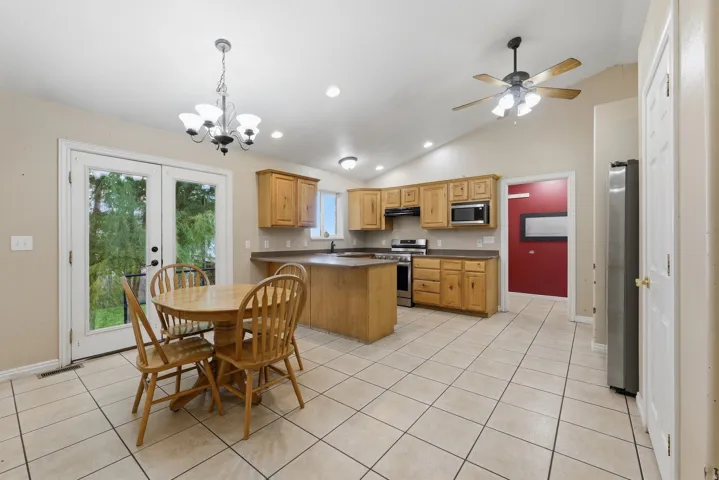 Vaulted ceilings, recessed lighting, and tile flooring