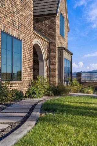 Brick exterior with dark window frames, an arched entry, and a prominent bay window