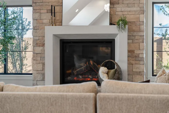 Stacked stone fireplace surround with a smooth-finish mantel and hearth