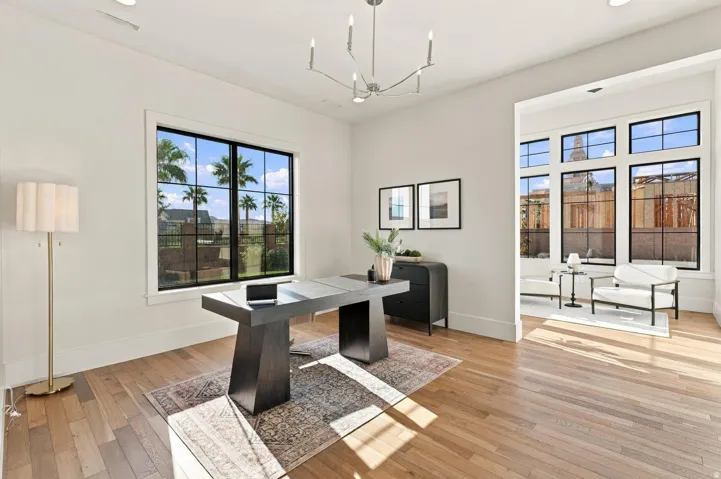 Hardwood flooring, recessed lighting, expansive black-framed windows, built-in cabinetry, and a modern linear chandelier