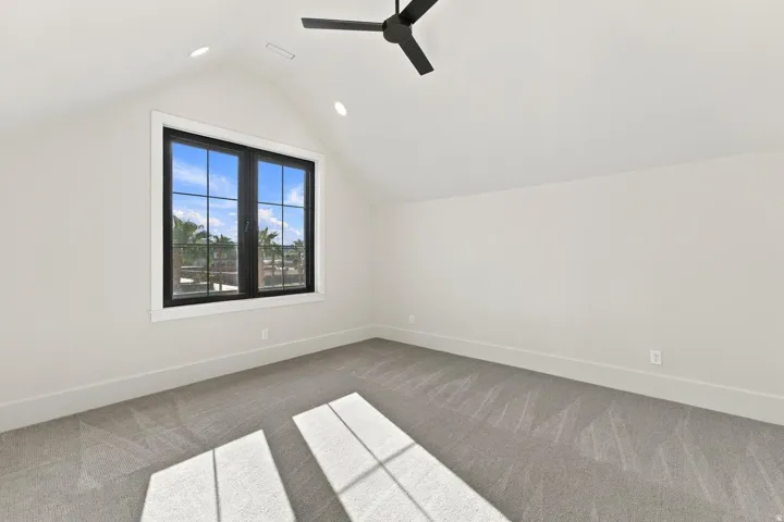 Vaulted ceiling with recessed lighting and a ceiling fan