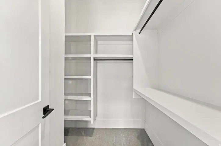 Custom closet system featuring built-in shelving, hanging rods, and an integrated storage bench
