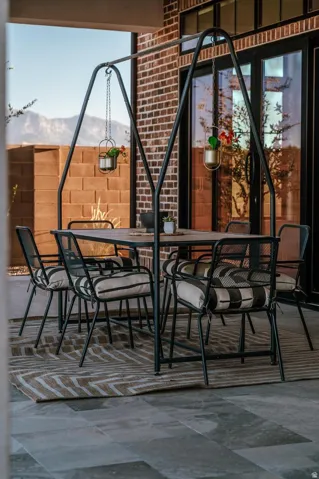 Patio featuring large format tile flooring, brick exterior wall, and multi-panel glass doors