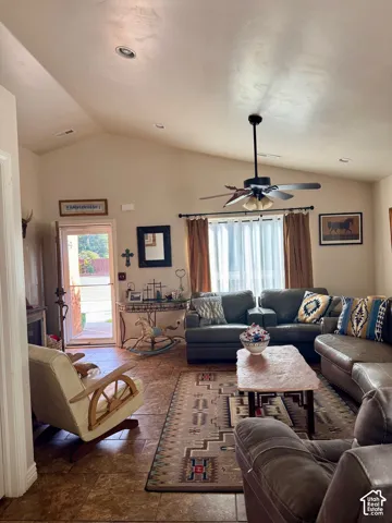 Vaulted ceilings with recessed lighting, ceiling fan, tile flooring, and a glass-paneled door