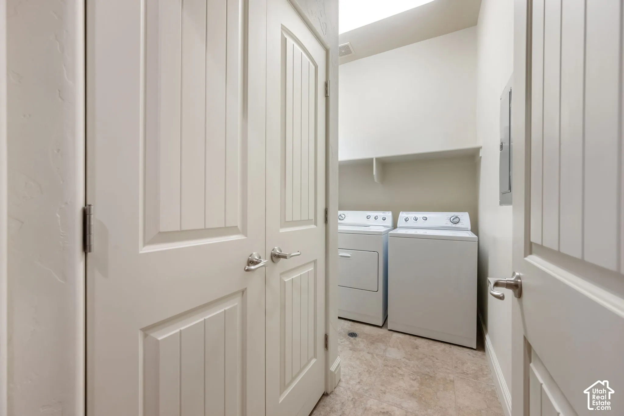 Dedicated laundry area featuring a shelf, tile flooring, and two white appliances