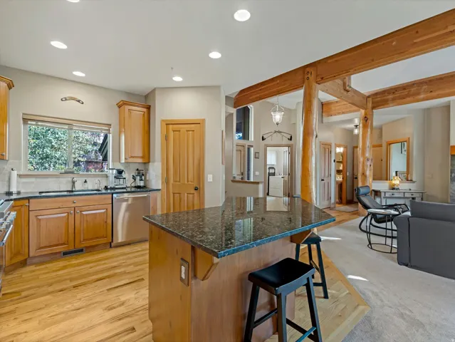 Kitchen featuring wood-finish cabinetry, stainless steel appliances, and a granite-finish island
