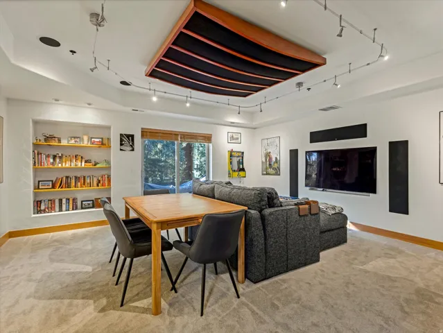Recessed built-in shelving, wood-framed sliding glass doors, built-in ceiling speakers, and track lighting