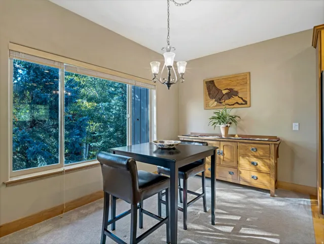 Recessed lighting, wood-finish base trim, and a chandelier with glass shades