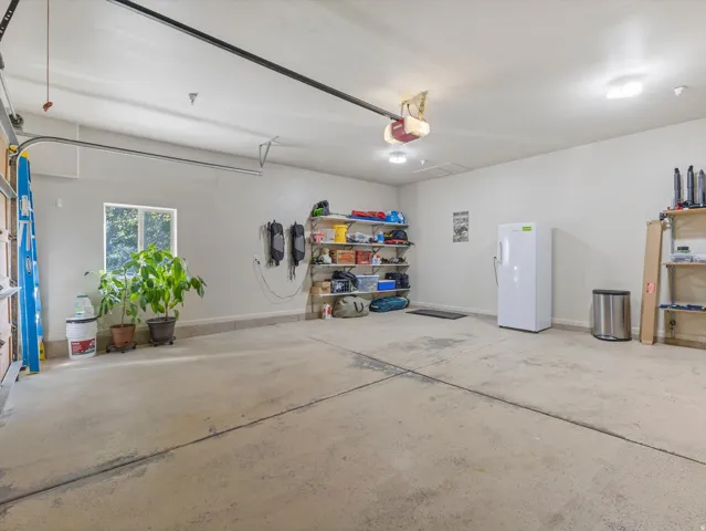 Concrete flooring, overhead lighting, and an automatic garage door opener