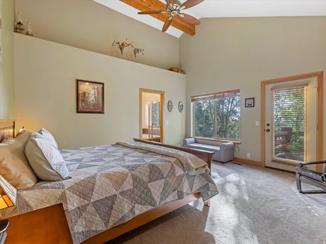 Vaulted ceiling with wood beam accents and ceiling fan