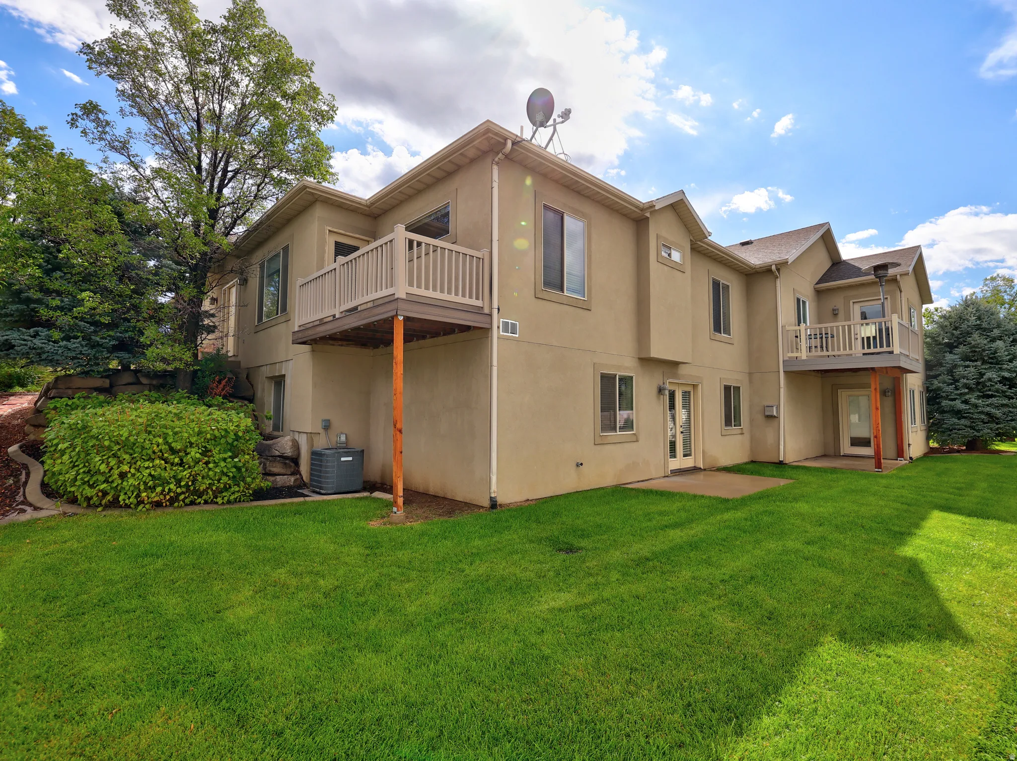 Expansive green lawn with mature trees and established landscaping