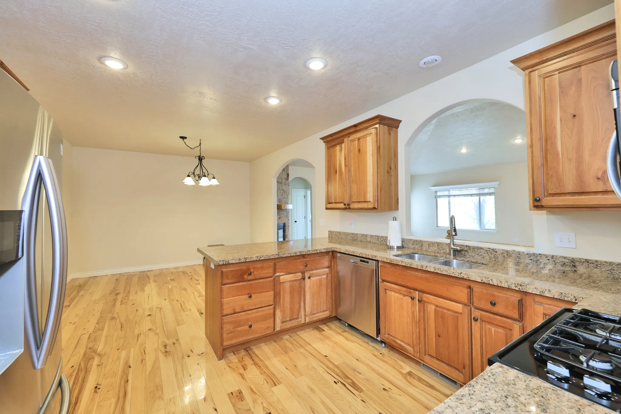 Wood-finish flooring, recessed lighting, and an arched entryway