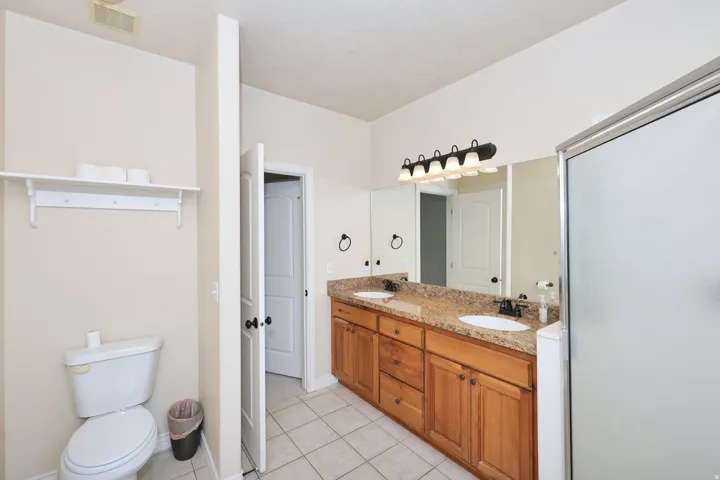 Dual vanity with undermount sinks, granite-style countertop, and wood-finish cabinetry