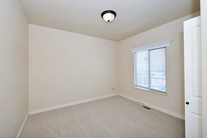Neutral wall finishes, recessed window, trim work, ceiling-mounted light fixture, and carpet flooring