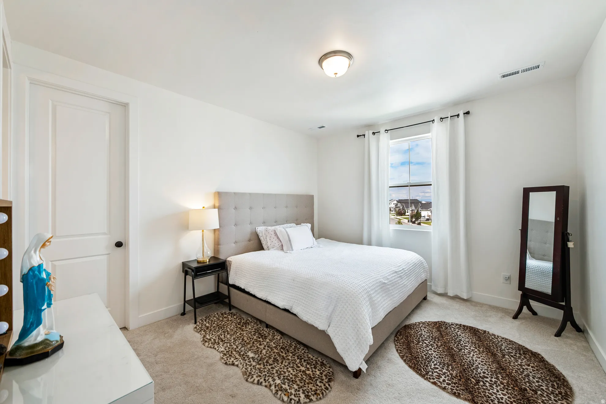 White interior walls, recessed single-panel door, carpet flooring, single window, and flush mount ceiling light fixture