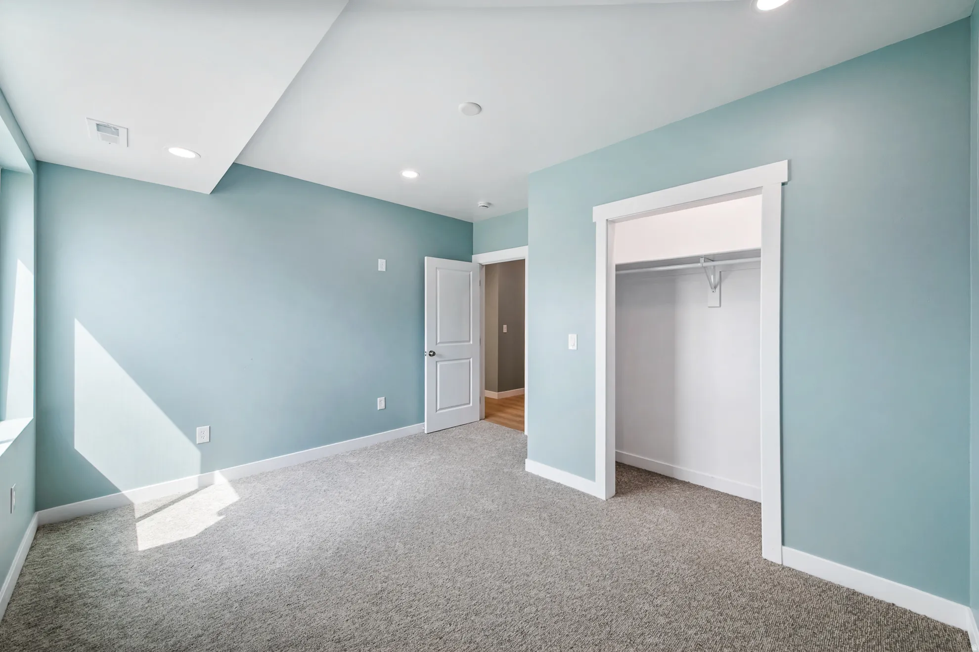 Wall-to-wall carpeting, recessed lighting, and a closet with hanging rod