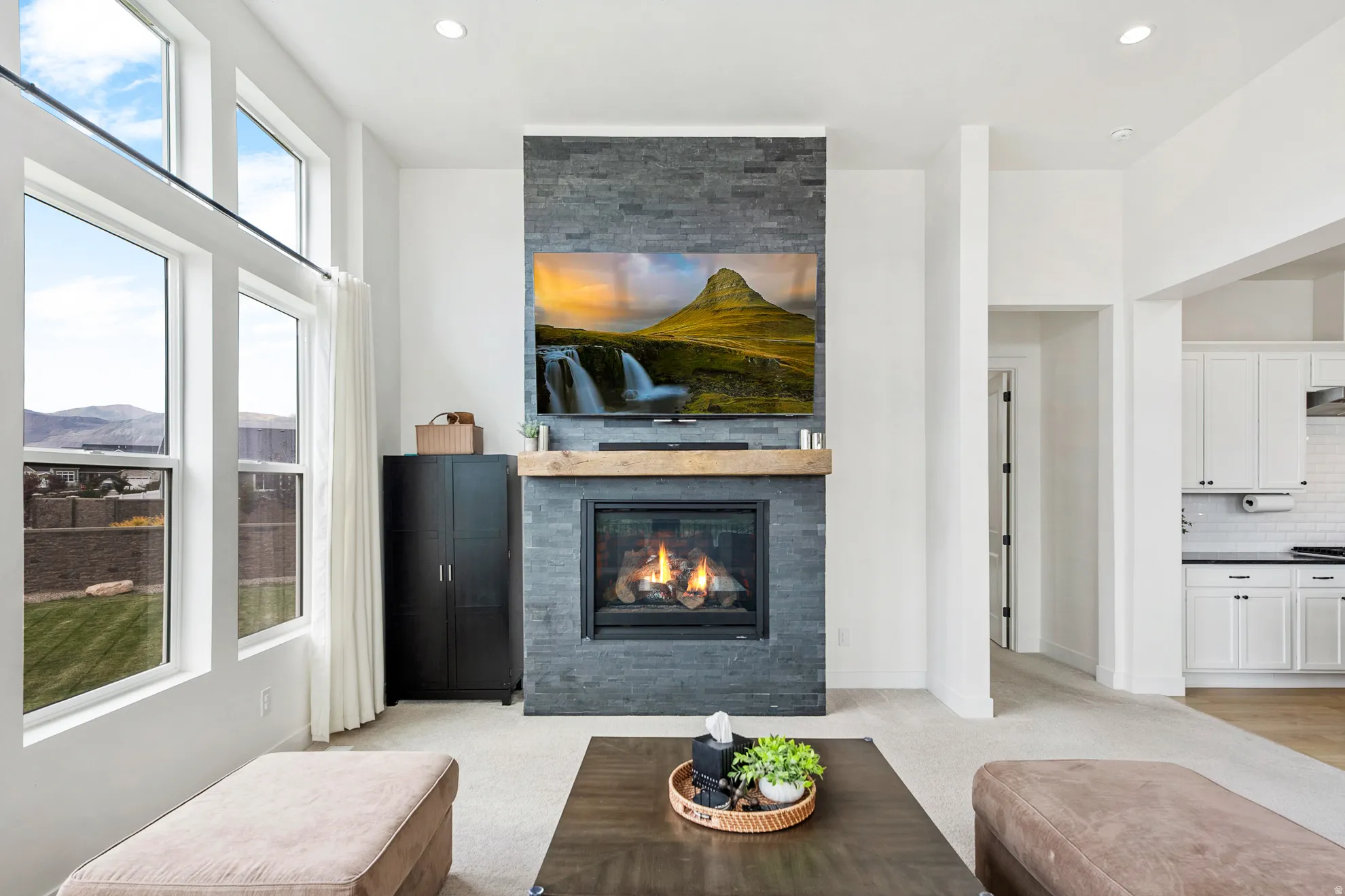 Stone-clad fireplace with a wood mantel, gas insert, and mounted display