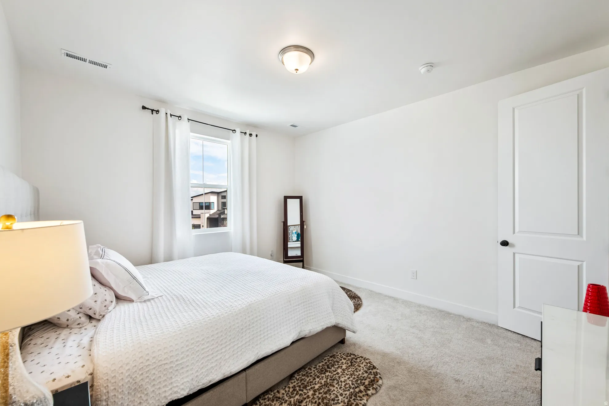 Recessed ceiling light, single window with roller shade, interior door with black hardware, and wall-to-wall carpeting