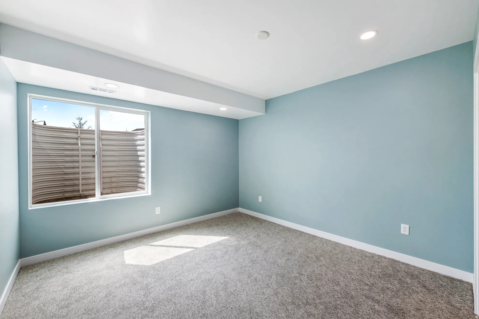 Carpeted flooring, recessed lighting, and a white window frame