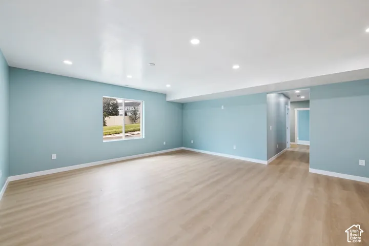 Spacious interior with wood-finish flooring, recessed lighting, and a neutral color palette