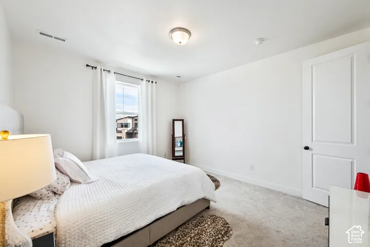 Recessed ceiling light, single window with roller shade, interior door with black hardware, and wall-to-wall carpeting