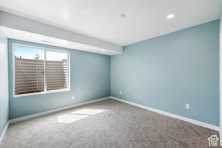 Carpeted flooring, recessed lighting, and a white window frame