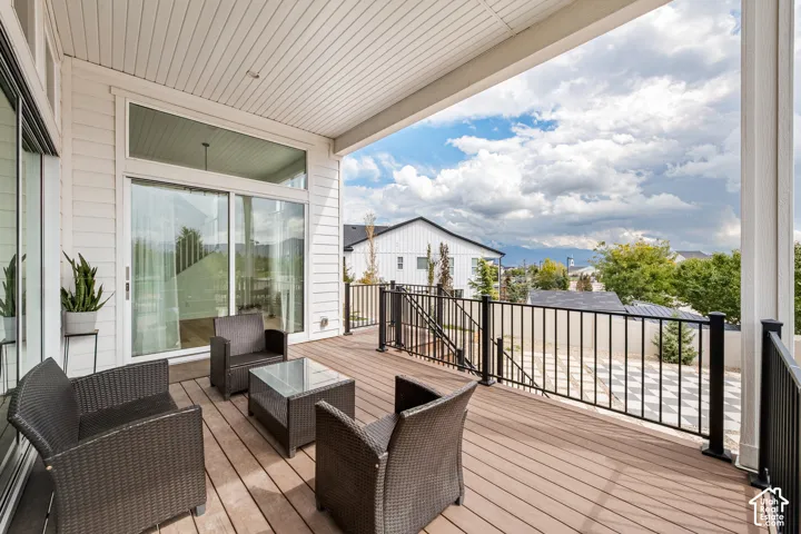 Covered outdoor deck with composite decking, white soffit ceiling, and black metal railing