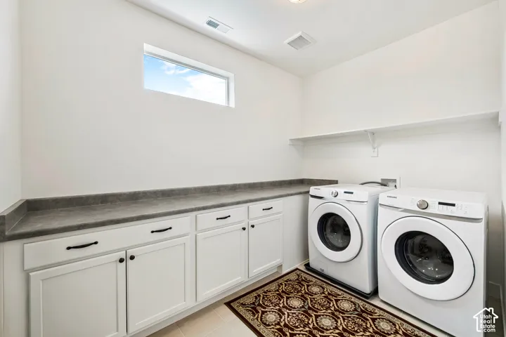White cabinetry with dark hardware, gray countertop, and an elevated shelf