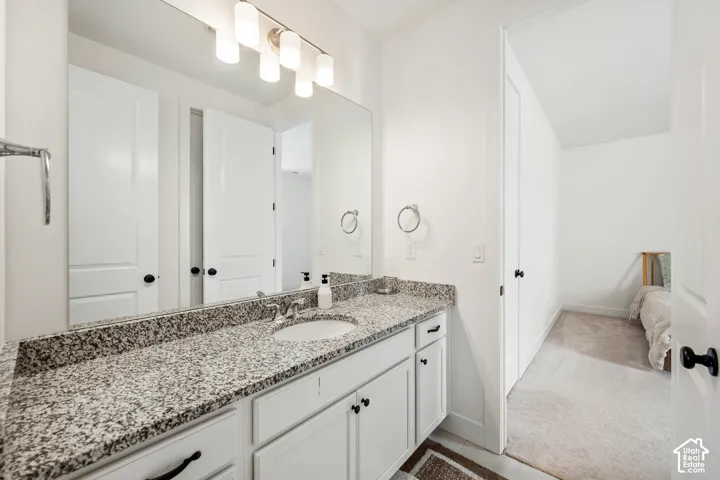 Vanity with granite countertop, undermount sink, and brushed nickel faucet