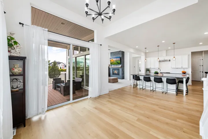 Spacious living area with wood-finish flooring, high ceilings, and a modern chandelier